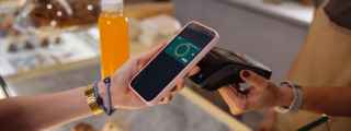 A Suncorp Bank customer using contactless payment at a cafe