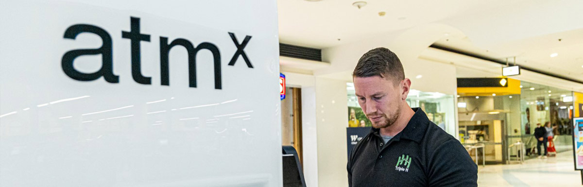 Person using ATM in shopping centre