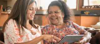 woman helping mother with ipad