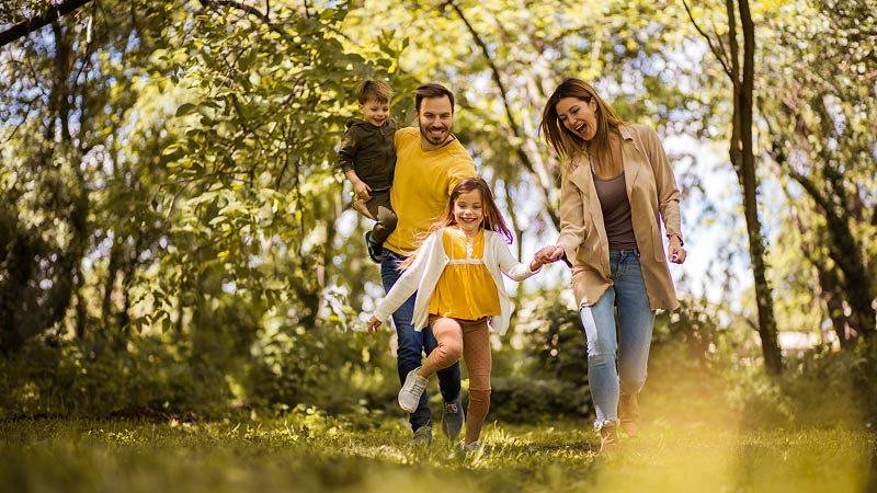 Suncorp Bank everyday accounts for kids - a family wearing yellow skipping through the forest 