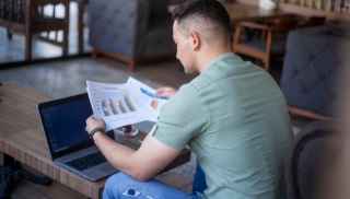 Man looking at printed graphs