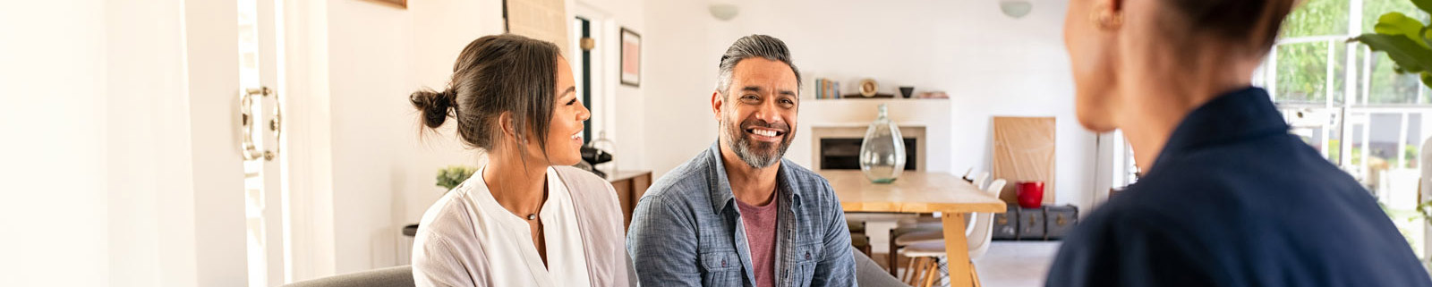 Middle aged couple sitting on the sofa talking to a realtor