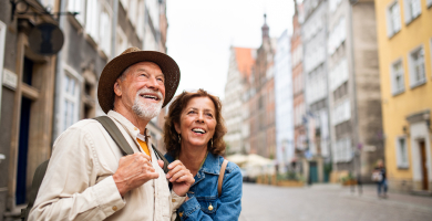 An older couple standing on a street of European heritage buildings