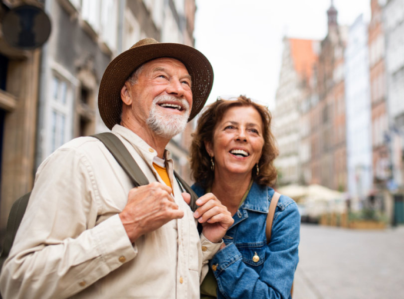 An older couple standing on a street of European heritage buildings