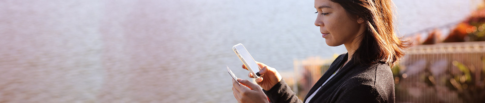 Woman holding credit card and tpying on mobile phone