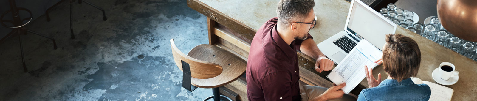 two-people-discussing-over-laptop-at-a-bar