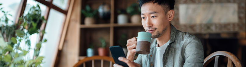 Man sitting on bench smiling at mobile phone