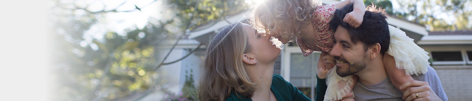 Mum kissing daughter riding fathers shoulders