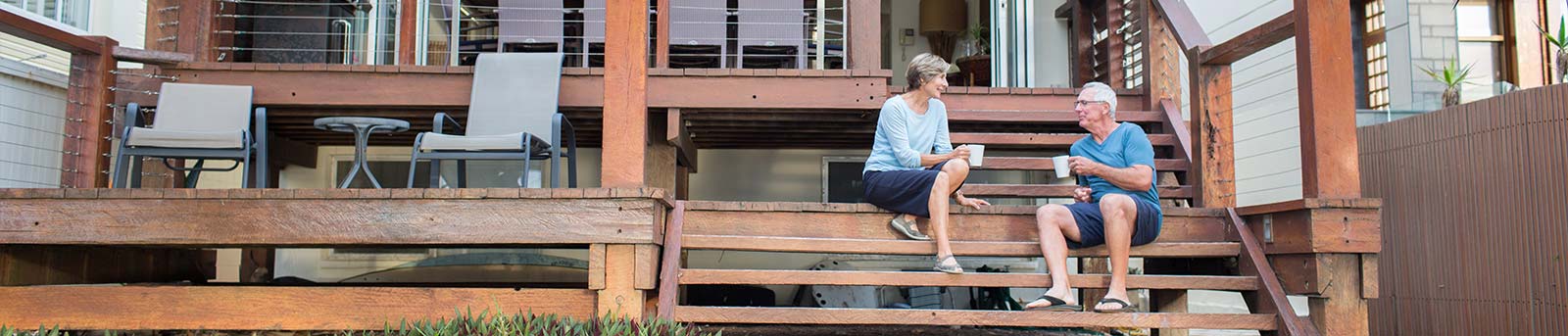 Older couple sitting on back stairs having coffee