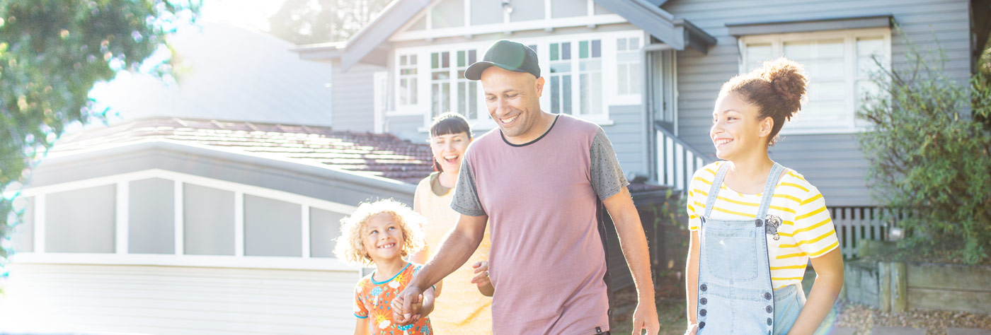 Family walking in front of house