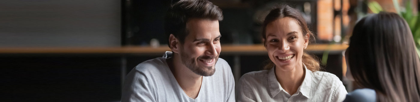 Young couple talking to advisor and smiling