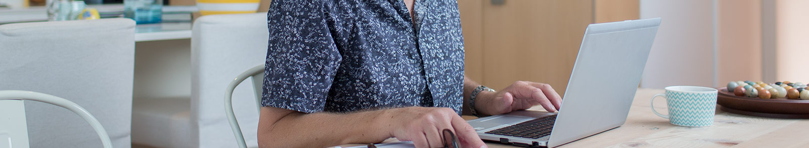 A woman is working on laptop in her office place