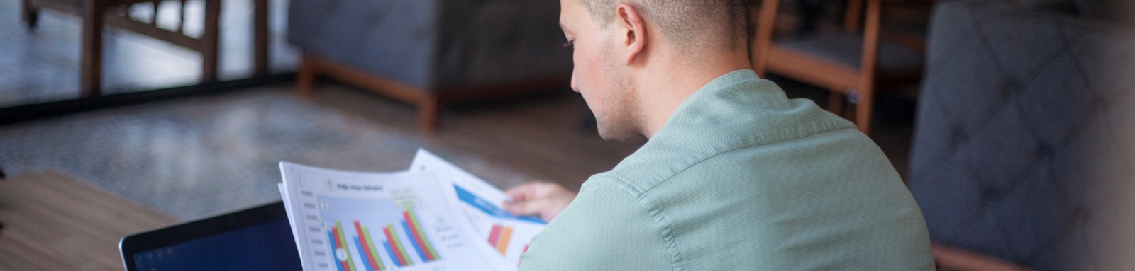 Man looking at printed graphs