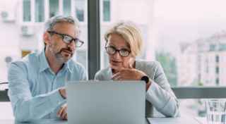 Two people sharing a laptop
