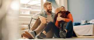 A couple hugging a baby near a toy teepee
