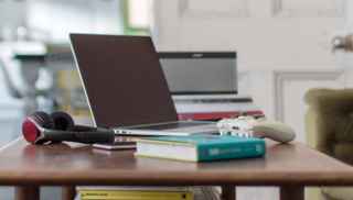 Laptop and book on table