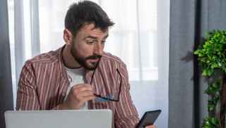male looking at phone at home