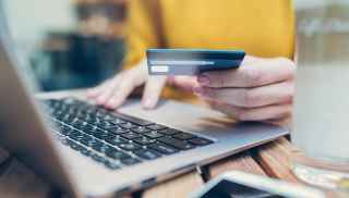 Woman using credit card on laptop